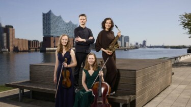 Eine Band mit der Elbphilharmonie im Hintergrund