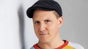 Person mit buntem Pulli im Portrait - Sebastian