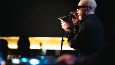 Seitenprofilaufnahme eines Sängers, der auf der Bühne performt.