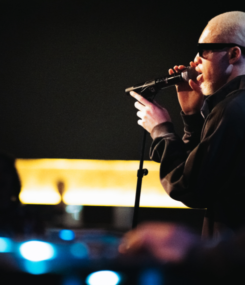 Seitenprofilaufnahme eines Sängers, der auf der Bühne performt.