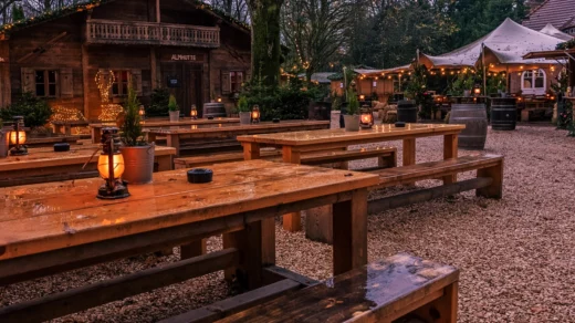 Viele Holzbänke und Tische sowie Holzhütten und weihnachtliche Deko