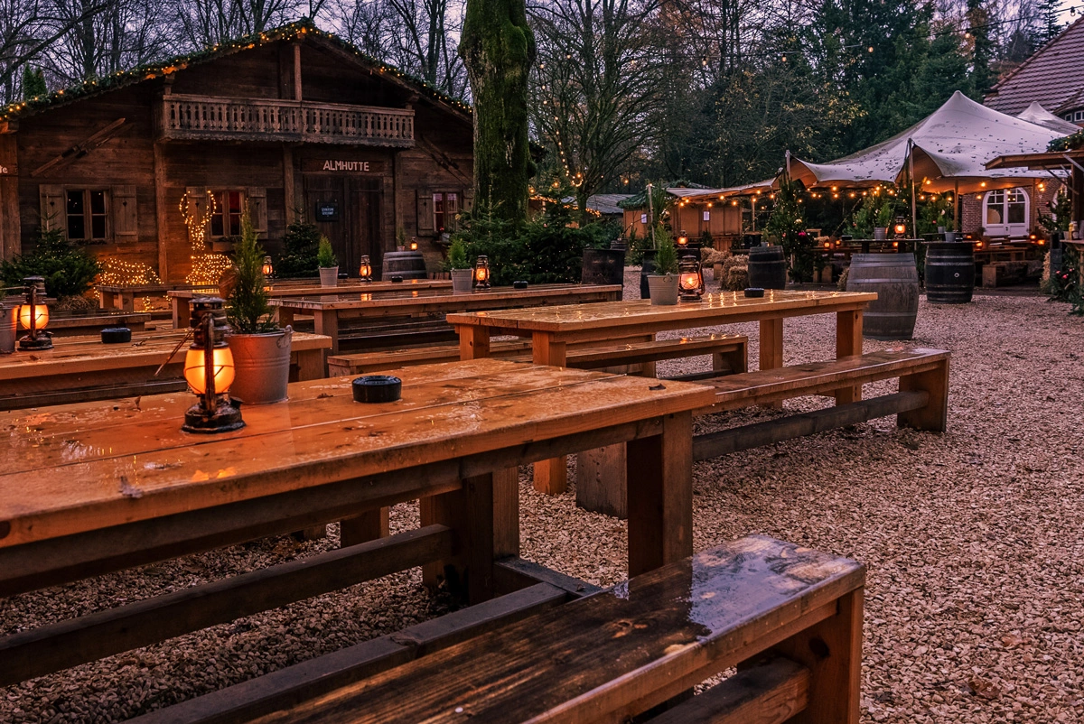 Viele Holzbänke und Tische sowie Holzhütten und weihnachtliche Deko