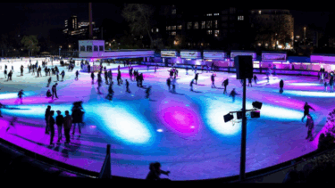 Viele Menschen auf einer bunt beleuchteten Eisfläche