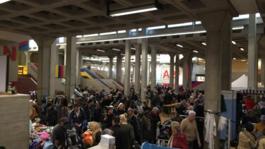Menschenmenge in einer Halle auf einem Flohmarkt