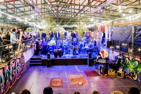 Gleishalle mit vielen Menschen und einer Band