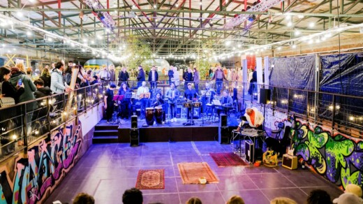 Gleishalle mit vielen Menschen und einer Band