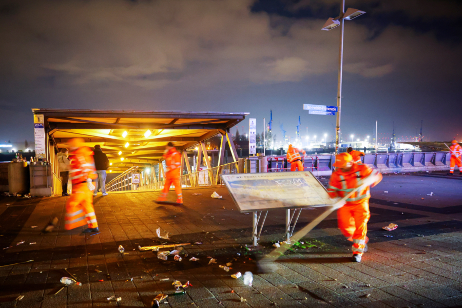 Mitarbeiter der Stadtreinigung Hamburg räumen abgebrannte Feuerwerkskörper und anderen Müll von der Promenade an den Landungsbrücken.