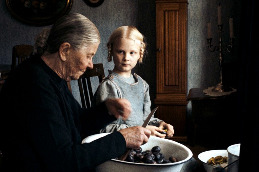 Eine alte Frau und ein Kind an einem Tisch