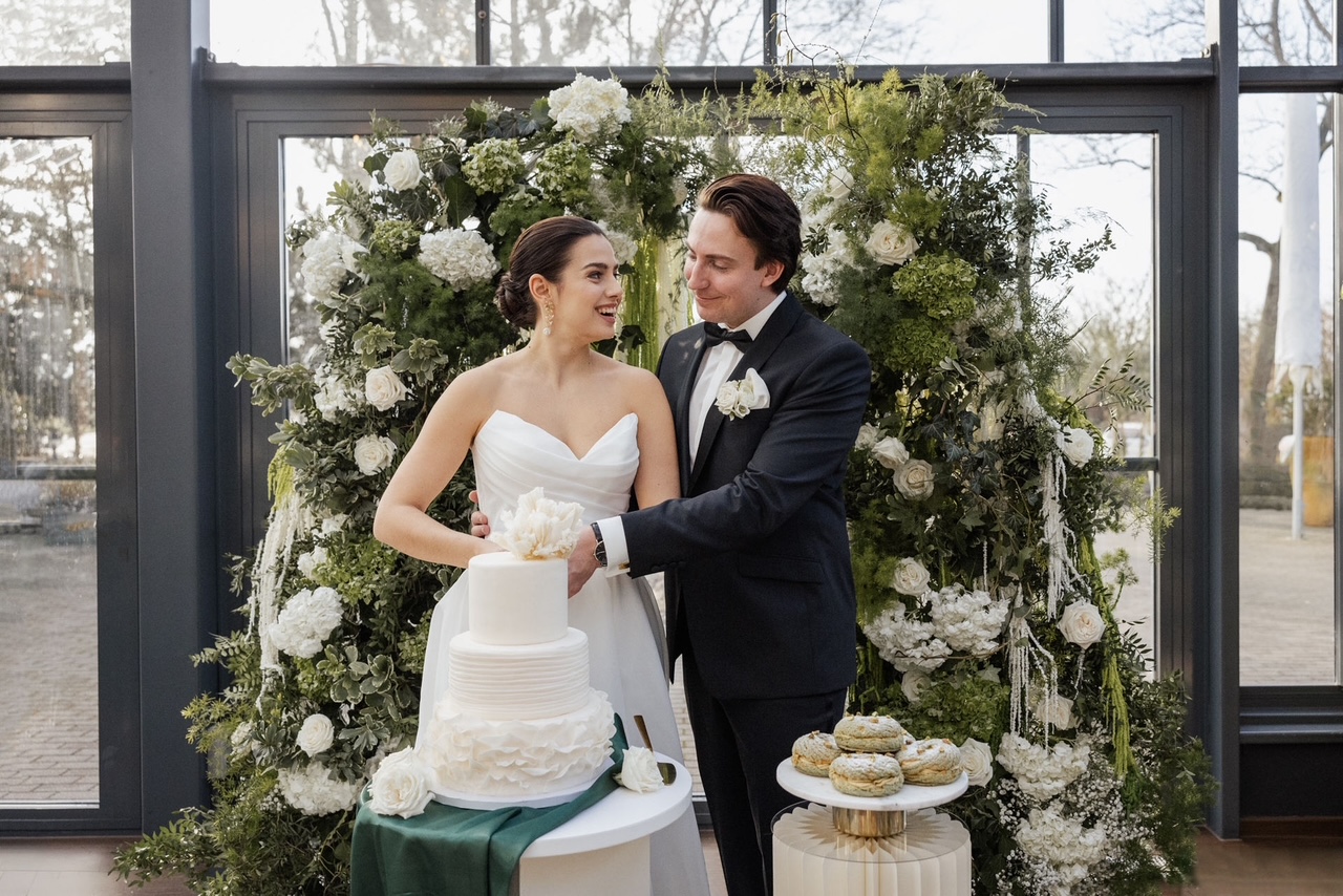 Nach einem alten Brauch hat die Person „Die Hosen in der Beziehung an“, die beim Hochzeitstorten anschnitt die Hand in Top hat