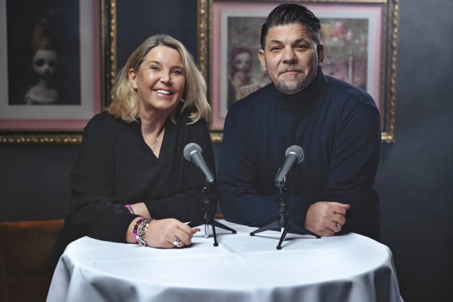 Tanya Kumst und Tim Mälzer stehen gemeinsam für den Podcast „Einmal ALLES, bitte!“ am Mikro / ©Christian Barz