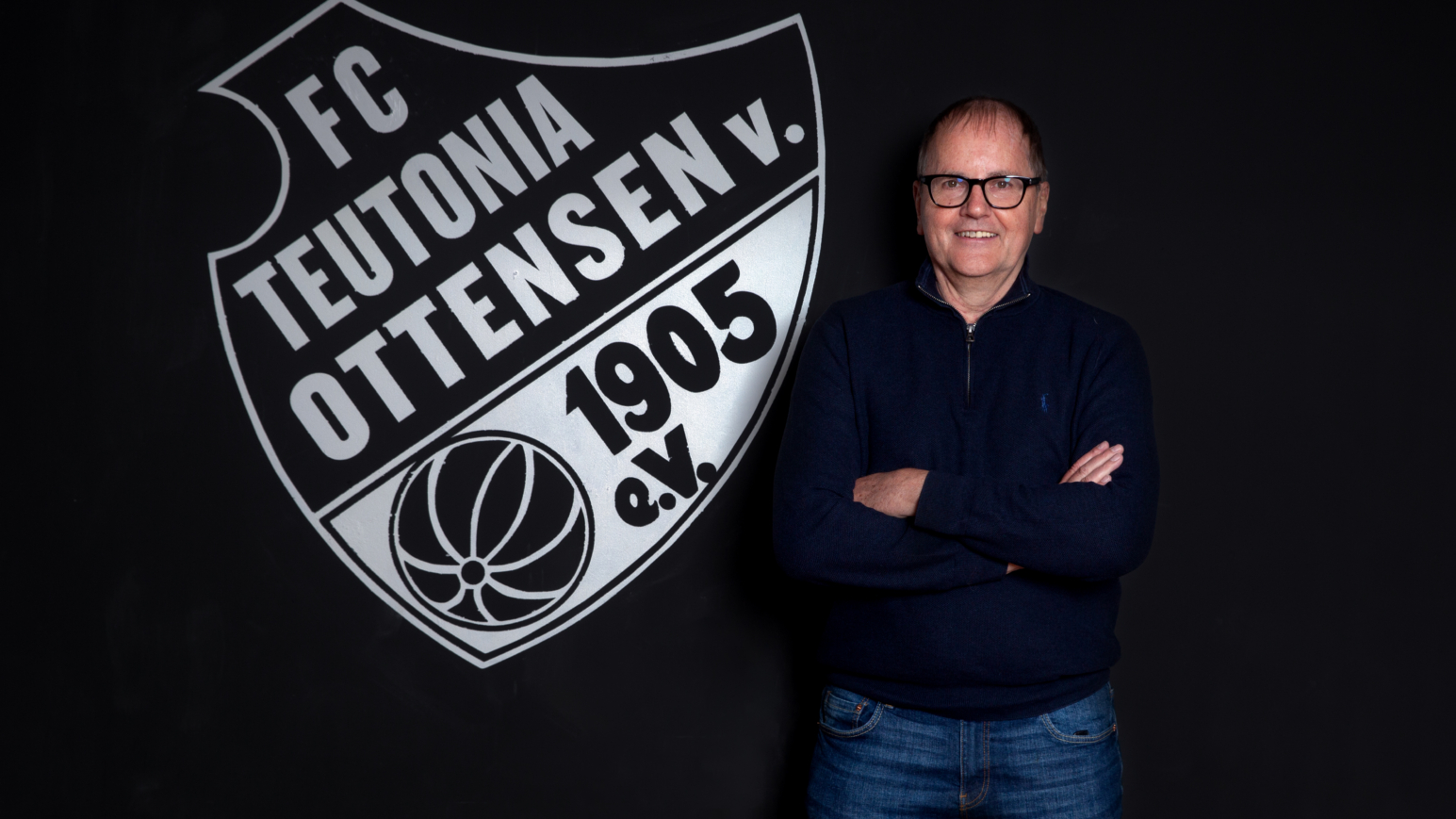 Siegmar Kuntze vor dem Vereinswappen des FC Teutonia Ottensen 1905 e.V.