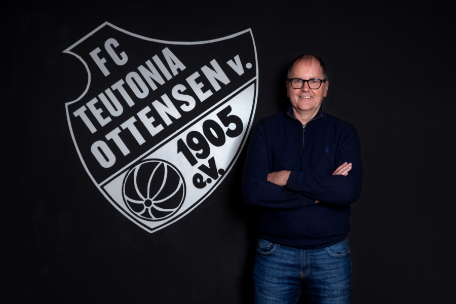 Siegmar Kuntze vor dem Vereinswappen des FC Teutonia Ottensen 1905 e.V.