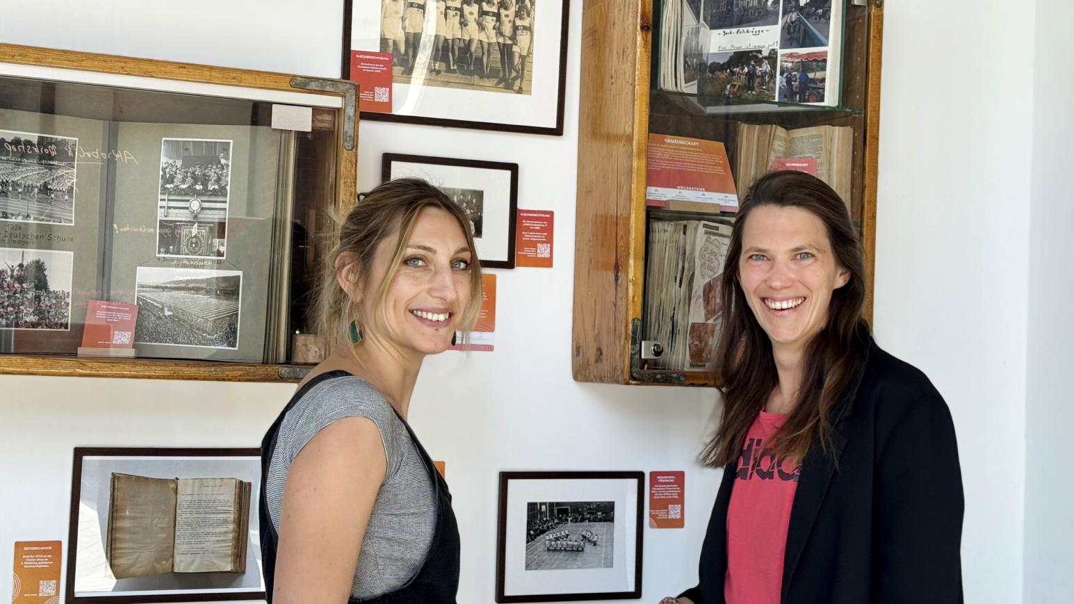 Nora Gille (l., Trainerin und Leiterin der Kletterhalle bei HT16) und Jennifer Grevenrath (Leiterin der Öffentlichkeitsarbeit bei HT16) vor Exponaten der Ausstellung „Zeitsprünge" ihres Vereins 