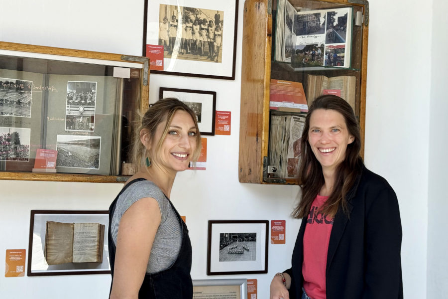 Nora Gille (l., Trainerin und Leiterin der Kletterhalle bei HT16) und Jennifer Grevenrath (Leiterin der Öffentlichkeitsarbeit bei HT16) vor Exponaten der Ausstellung „Zeitsprünge" ihres Vereins 