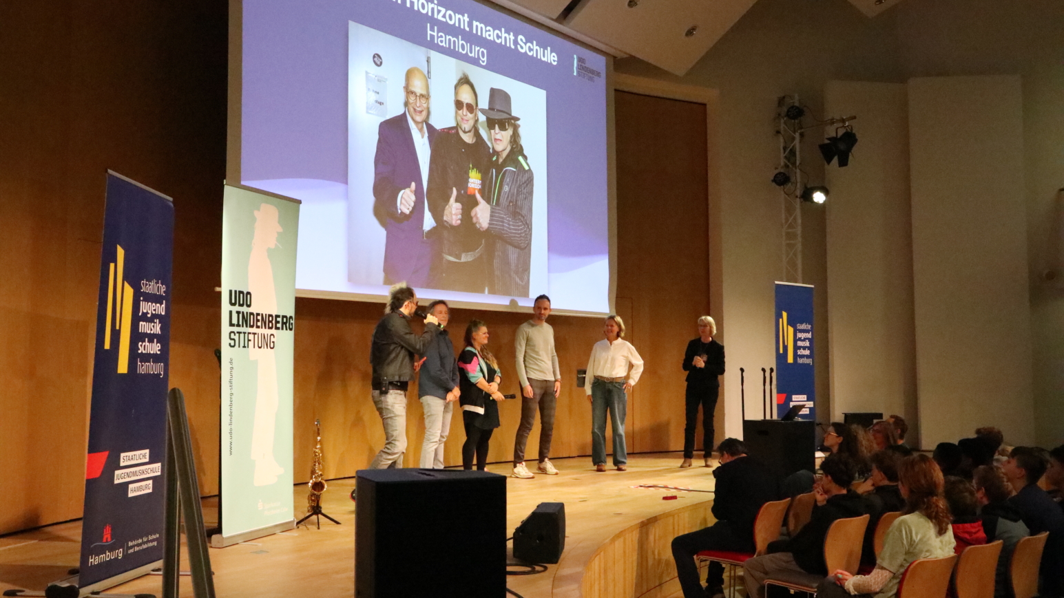Auf der Bühne: Die Künstlerische Leitung des Originalmusicals und des Projektes Noah Fischer (links) und Elisabeth Engstler (rechts) mit Vertretern der beiden Gewinner-Schulen (Mitte), der ATW Hamburg und des Gymnasium Farmsen